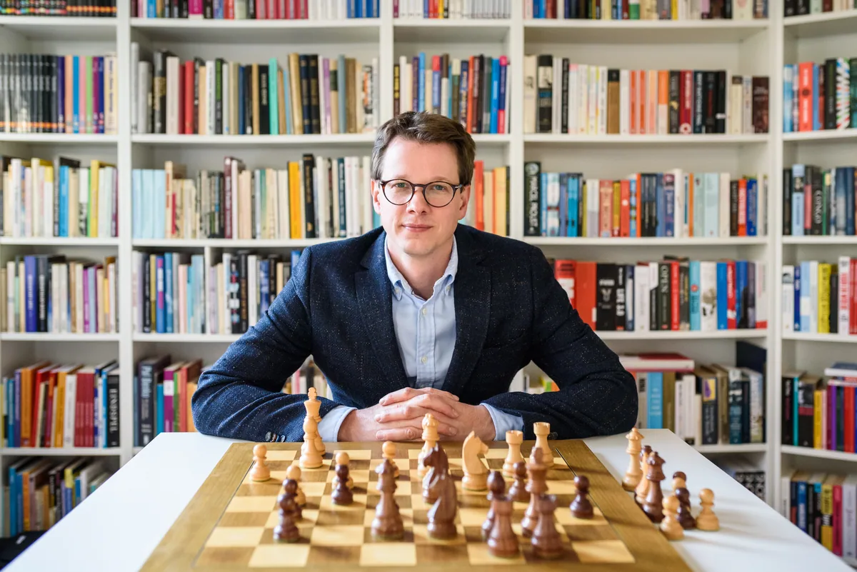 Portret aan een schaakbord voor een boekenkast, uit de aangeleverde Jan-fotoserie